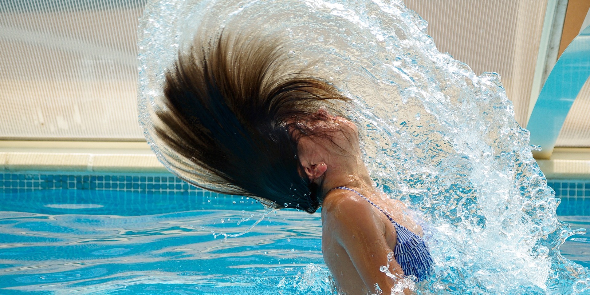 Lady throwing hair back in swimming pool