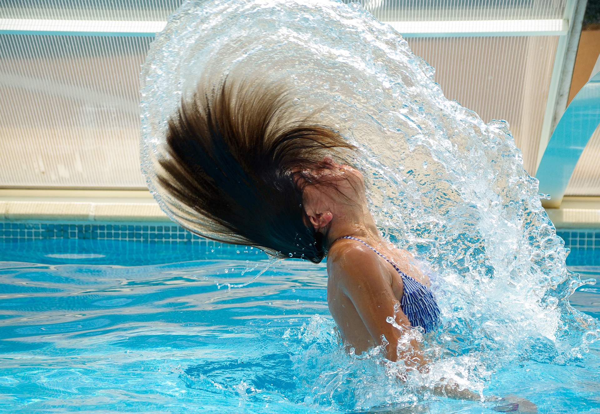 Lady throwing hair back in swimming pool
